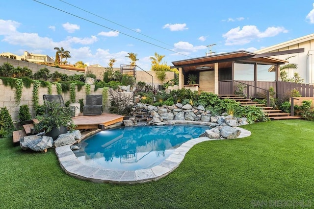 view of swimming pool with a yard and a wooden deck