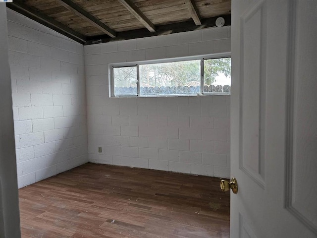 spare room featuring beam ceiling, dark hardwood / wood-style floors, and wooden ceiling