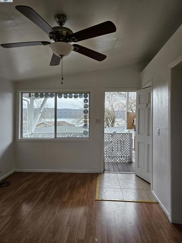 unfurnished sunroom with vaulted ceiling, plenty of natural light, and ceiling fan