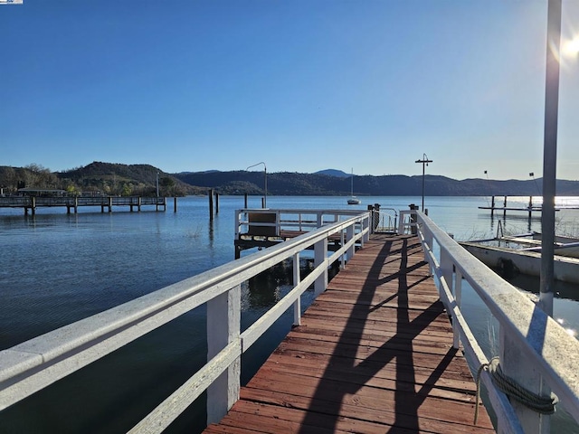 view of dock with a water and mountain view