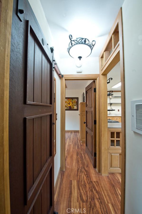 hall with dark hardwood / wood-style floors and a barn door