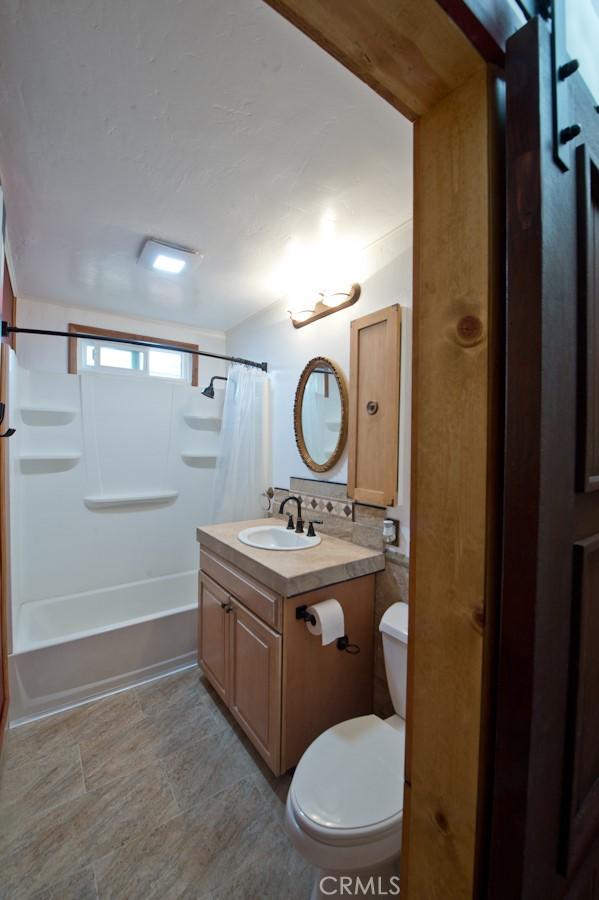 full bathroom with vanity, shower / bath combo, and toilet