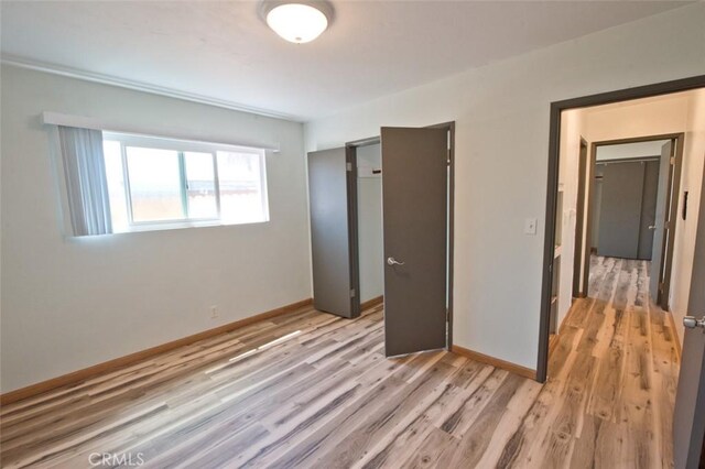 unfurnished bedroom featuring light wood-type flooring and a closet