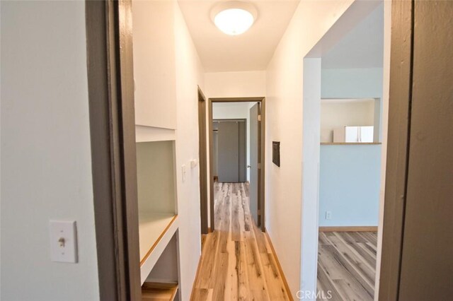 corridor with light hardwood / wood-style floors