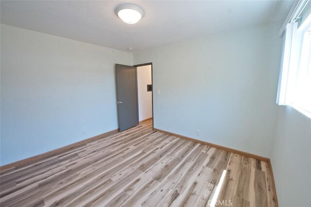 spare room with light hardwood / wood-style flooring