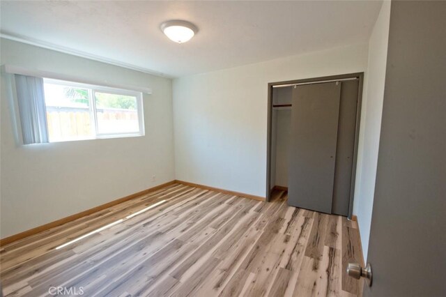 unfurnished bedroom featuring light hardwood / wood-style floors and a closet