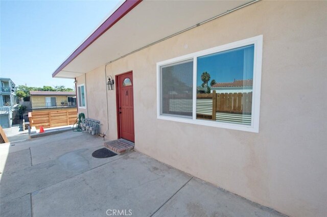 view of exterior entry featuring a patio area