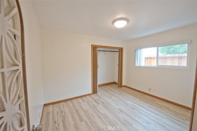 unfurnished bedroom featuring light hardwood / wood-style floors and a closet