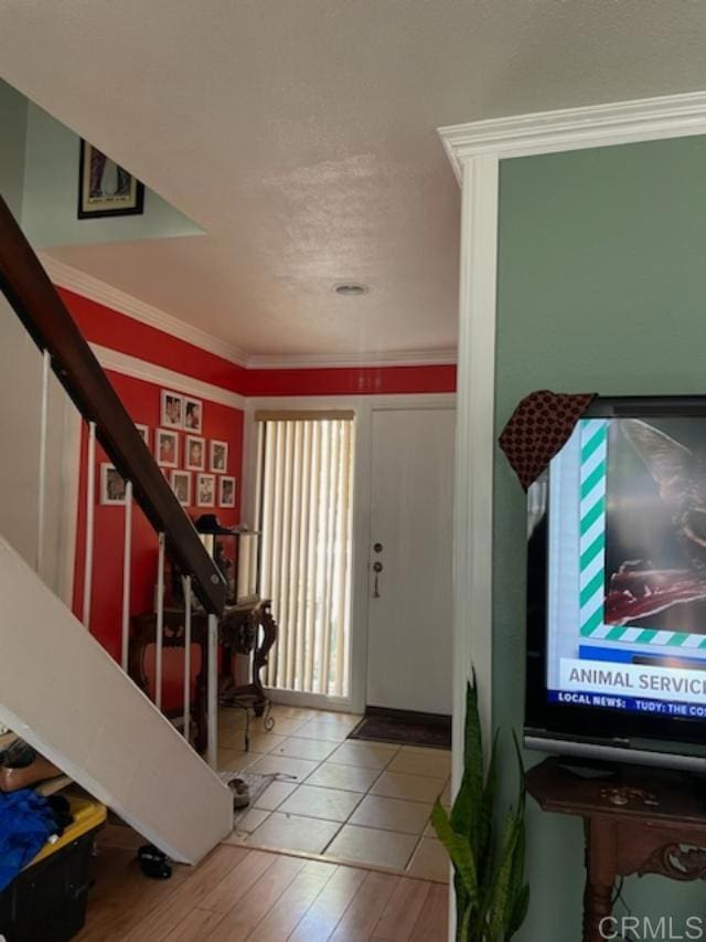 entryway featuring tile patterned flooring and ornamental molding