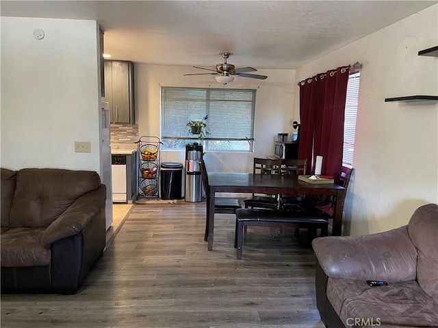 dining space with wood-type flooring, ceiling fan, and a healthy amount of sunlight