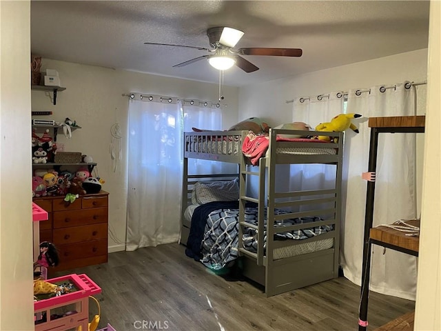 bedroom with ceiling fan, dark wood-type flooring, and a textured ceiling