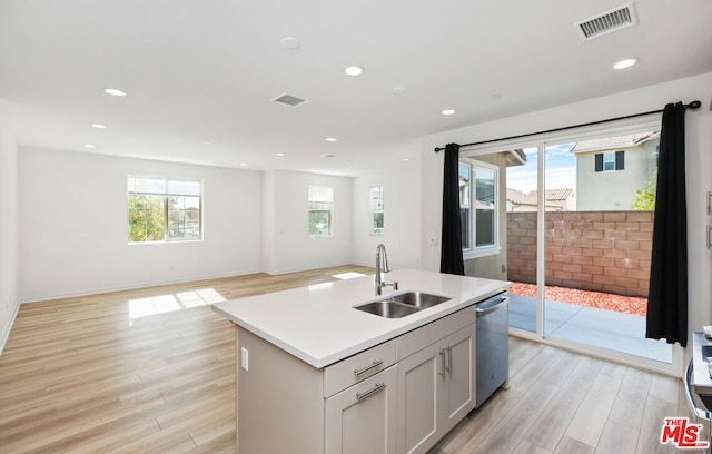 kitchen with a wealth of natural light, sink, and a center island with sink