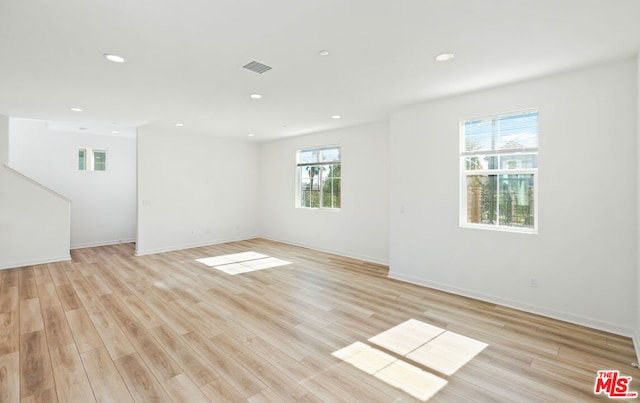 empty room featuring a healthy amount of sunlight and light wood-type flooring