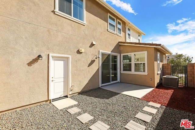 rear view of house with central AC unit and a patio area