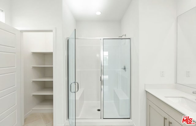 bathroom with tile patterned flooring, vanity, and an enclosed shower