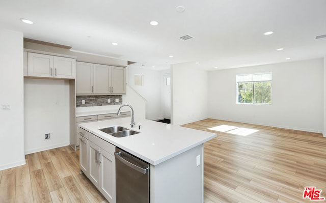 kitchen featuring white cabinets, a center island with sink, stainless steel dishwasher, and sink