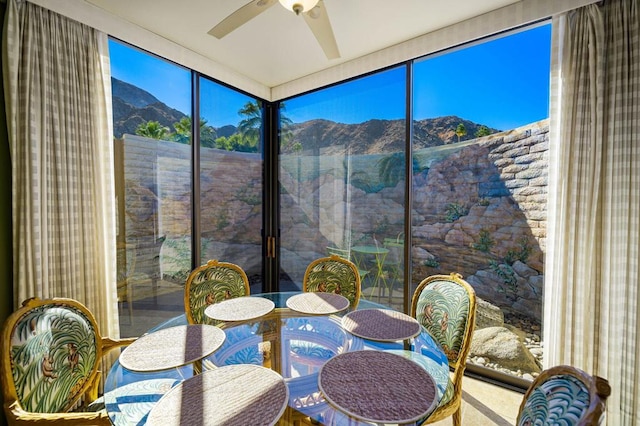 sunroom featuring a mountain view, ceiling fan, and plenty of natural light