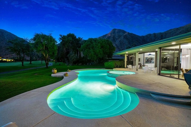 view of pool featuring a mountain view, a yard, a patio, and an in ground hot tub