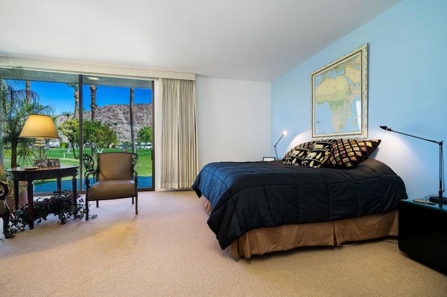 carpeted bedroom with a mountain view and access to outside