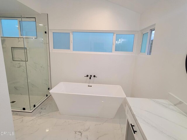 bathroom with vanity, a healthy amount of sunlight, shower with separate bathtub, and vaulted ceiling