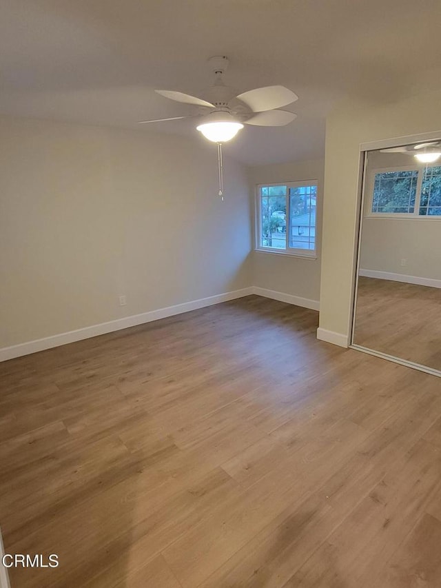 unfurnished bedroom with a closet, light hardwood / wood-style flooring, and ceiling fan