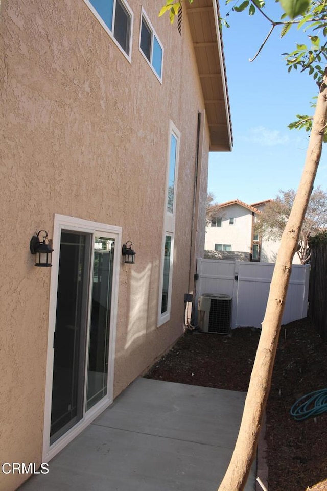 view of property exterior with cooling unit and a patio