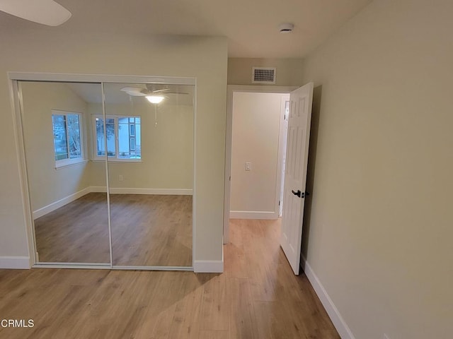 unfurnished bedroom featuring a closet and light wood-type flooring