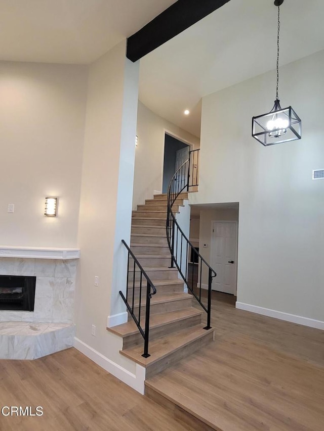 stairs with a tiled fireplace and hardwood / wood-style flooring