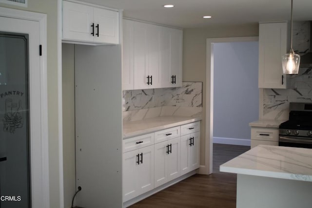 kitchen featuring white cabinetry, light stone counters, stainless steel range oven, pendant lighting, and decorative backsplash