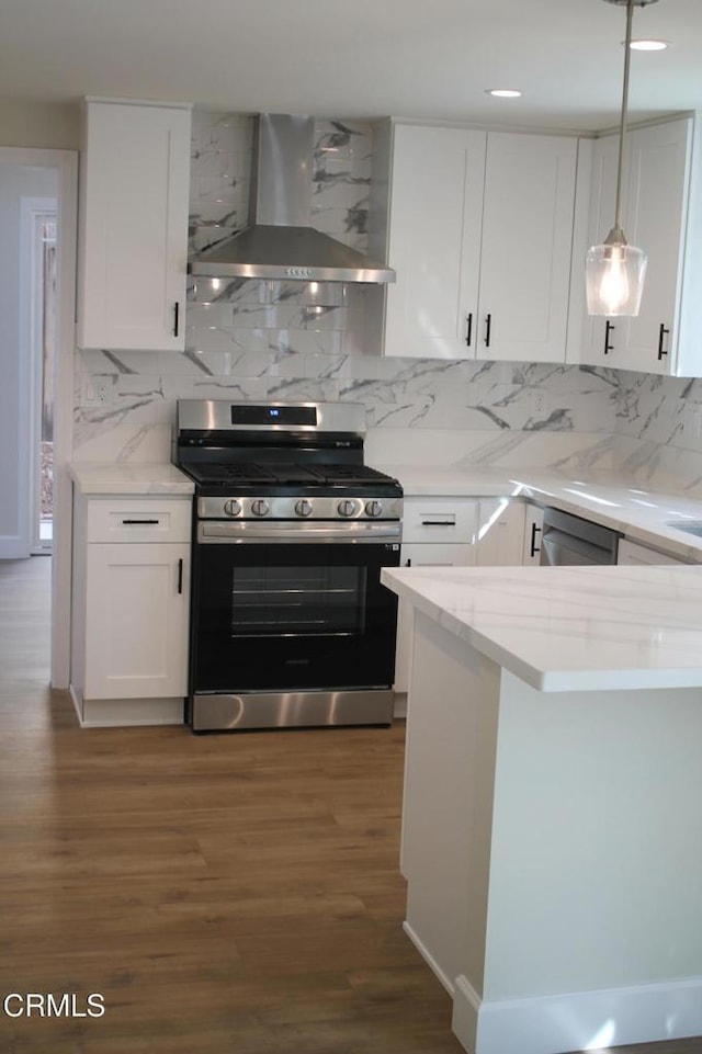 kitchen featuring decorative backsplash, dark hardwood / wood-style flooring, stainless steel range, wall chimney range hood, and white cabinetry