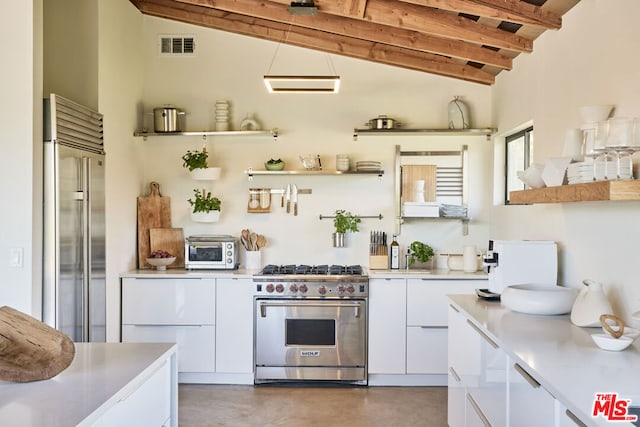 kitchen with vaulted ceiling with beams, high end appliances, and white cabinetry