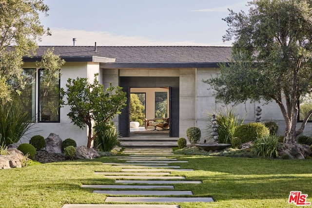 property entrance with a lawn