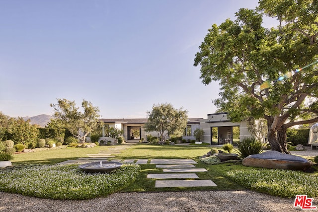 view of front facade featuring a mountain view and a front yard