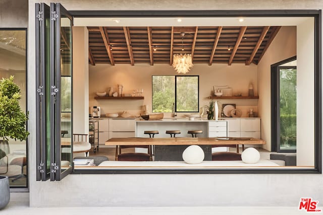 interior space featuring hardwood / wood-style floors, lofted ceiling with beams, wooden ceiling, and sink