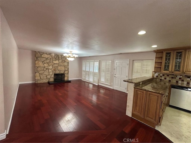 unfurnished living room featuring a fireplace, dark hardwood / wood-style flooring, and a notable chandelier