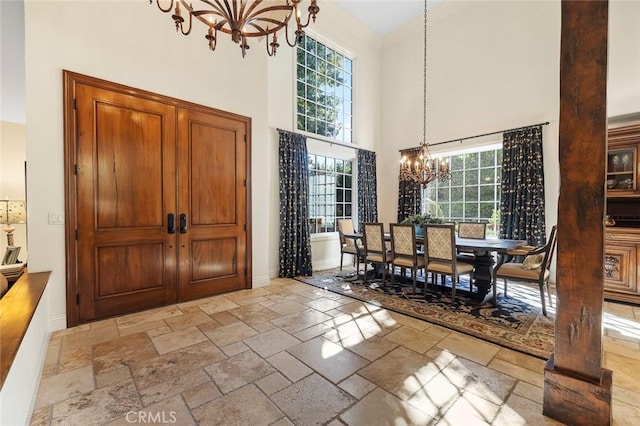 dining area featuring an inviting chandelier and a towering ceiling