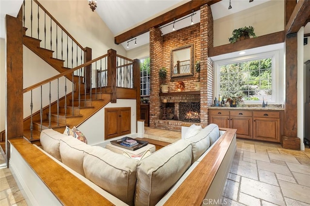 living room with a brick fireplace and high vaulted ceiling