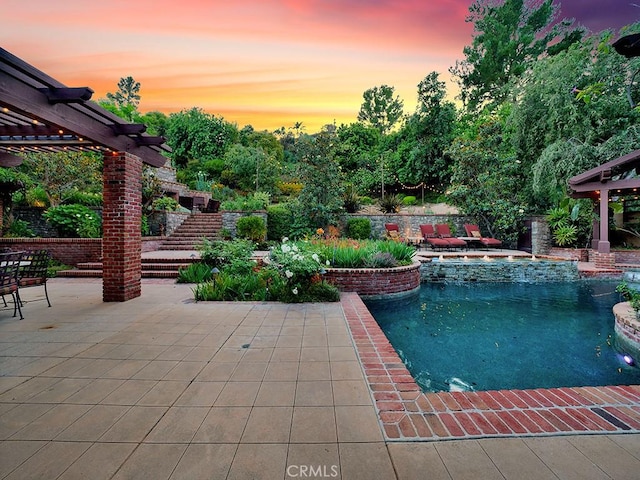 pool at dusk with a patio, an in ground hot tub, and a pergola