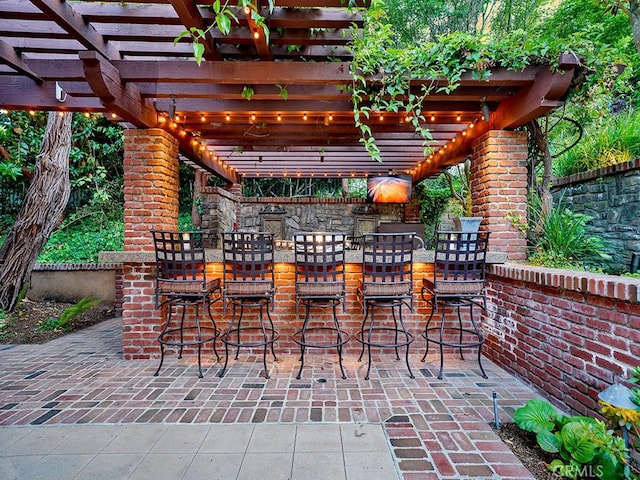 view of patio featuring exterior bar and a pergola