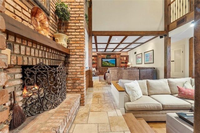 living room with beamed ceiling, coffered ceiling, and a fireplace