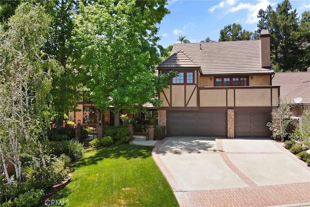 tudor-style house with a garage and a front lawn