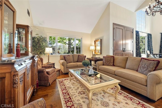 living room featuring an inviting chandelier, dark hardwood / wood-style flooring, and high vaulted ceiling