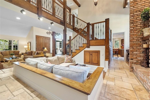 living room with beam ceiling and high vaulted ceiling