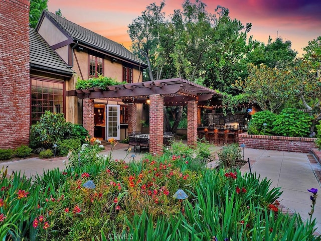 patio terrace at dusk featuring a pergola