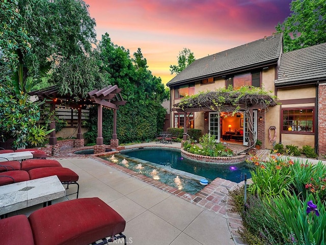 pool at dusk featuring a pergola and a patio