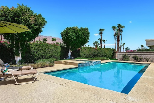 view of pool with a mountain view, a patio, and an in ground hot tub