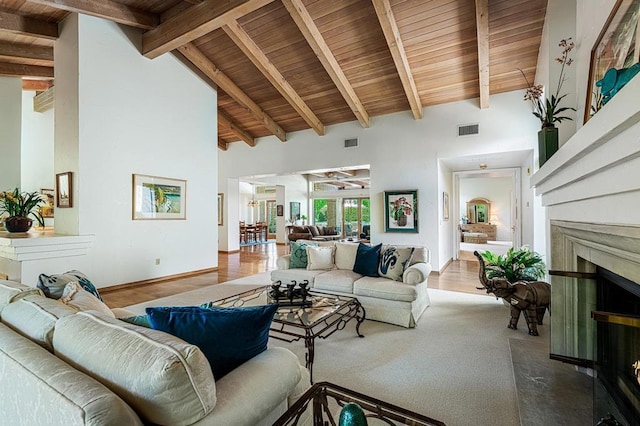 living room featuring wood ceiling, high vaulted ceiling, a premium fireplace, and beamed ceiling