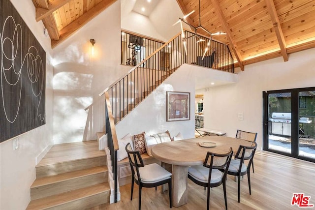 dining space featuring a healthy amount of sunlight, light wood-type flooring, high vaulted ceiling, and wooden ceiling