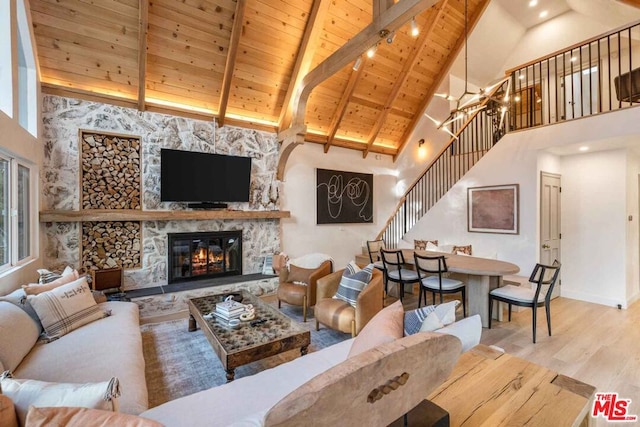 living room with wood ceiling, wood-type flooring, beam ceiling, high vaulted ceiling, and a fireplace