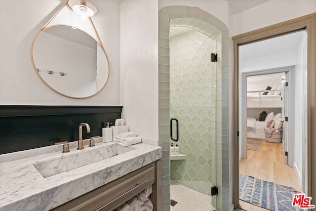 bathroom featuring a shower with door, vanity, and hardwood / wood-style flooring